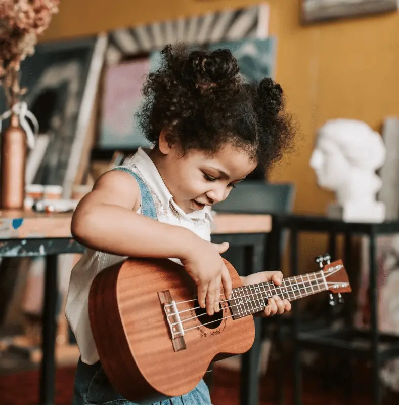 Petite fille qui joue du ukulélé dans un environnement Montessori